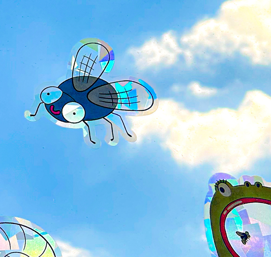 Colorful bug suncatcher on window casting prismatic light patterns