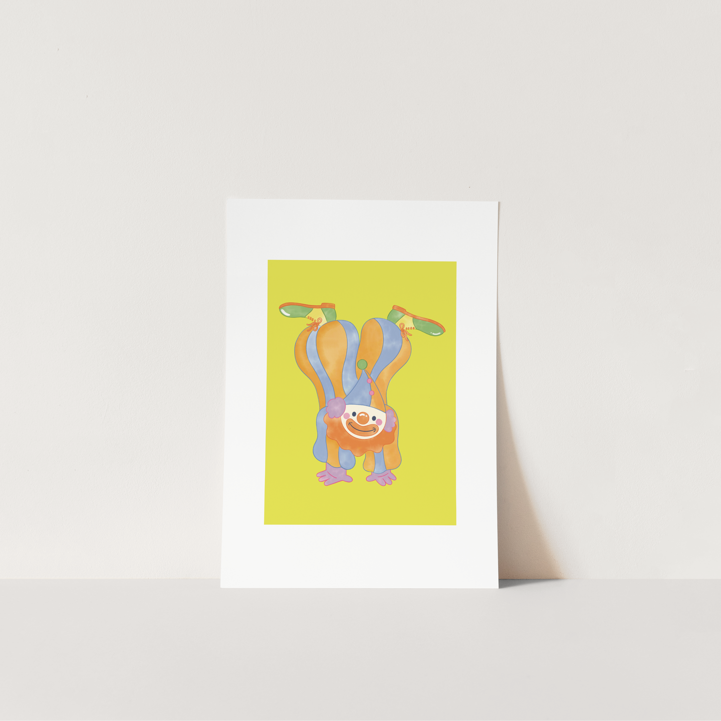 Framed artwork of a colorful clown design on a white surface with a light background