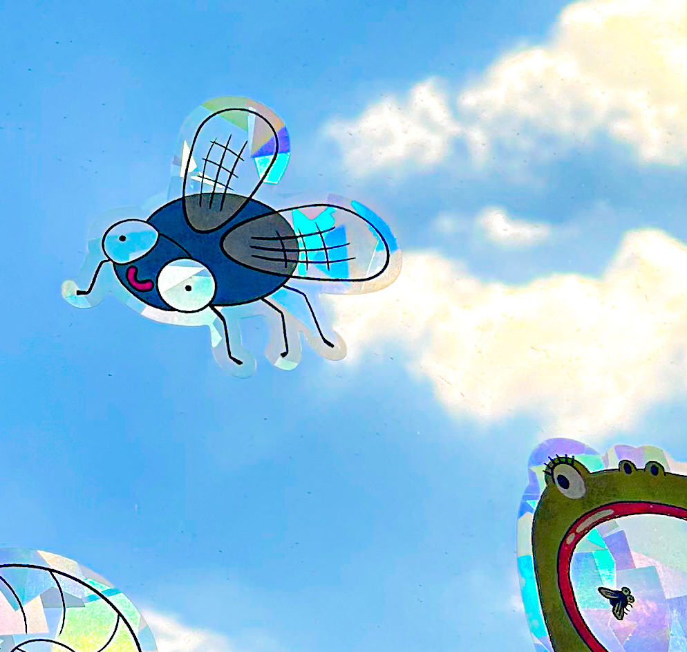 Colorful bug suncatcher on window casting prismatic light patterns