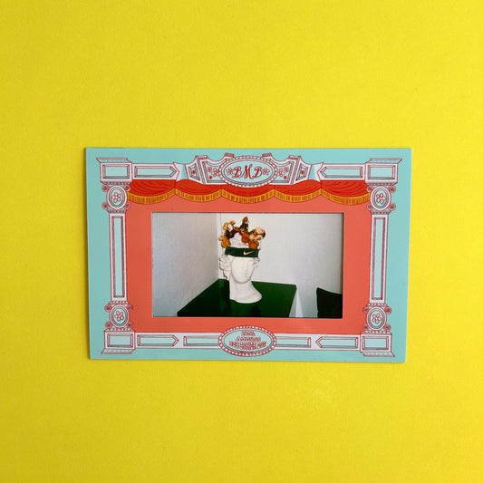 Decorative frame with a head sculpture on a yellow background